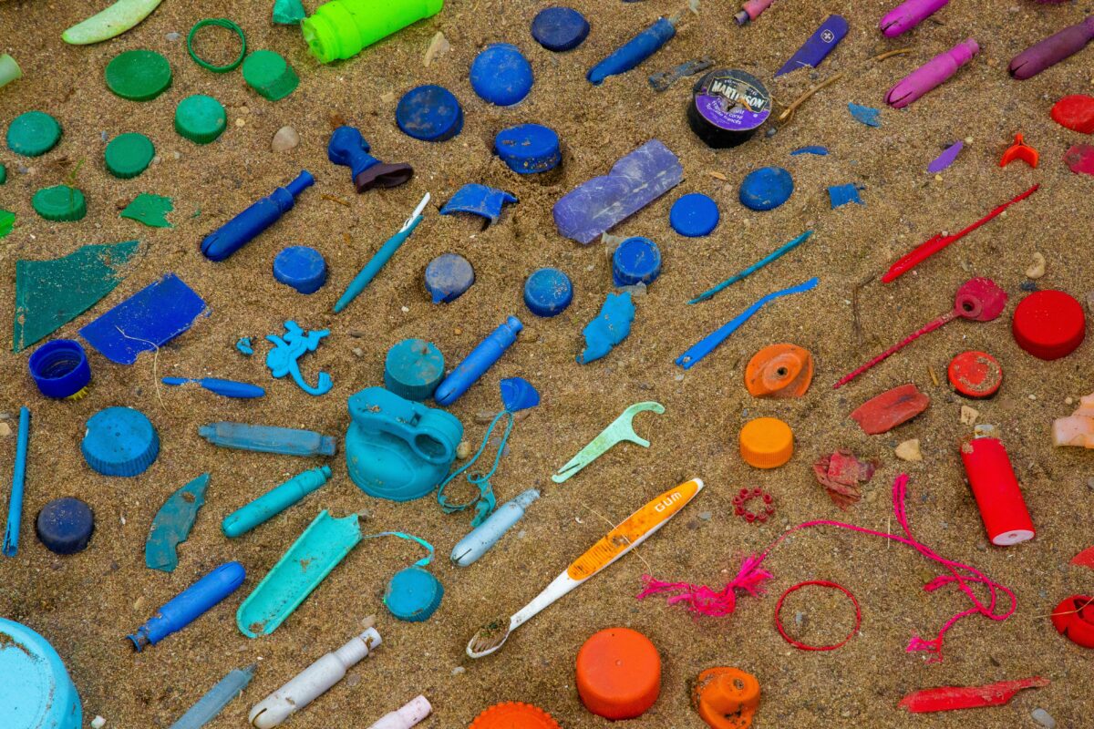 colorful plastic object litter sand in a rainbow pattern