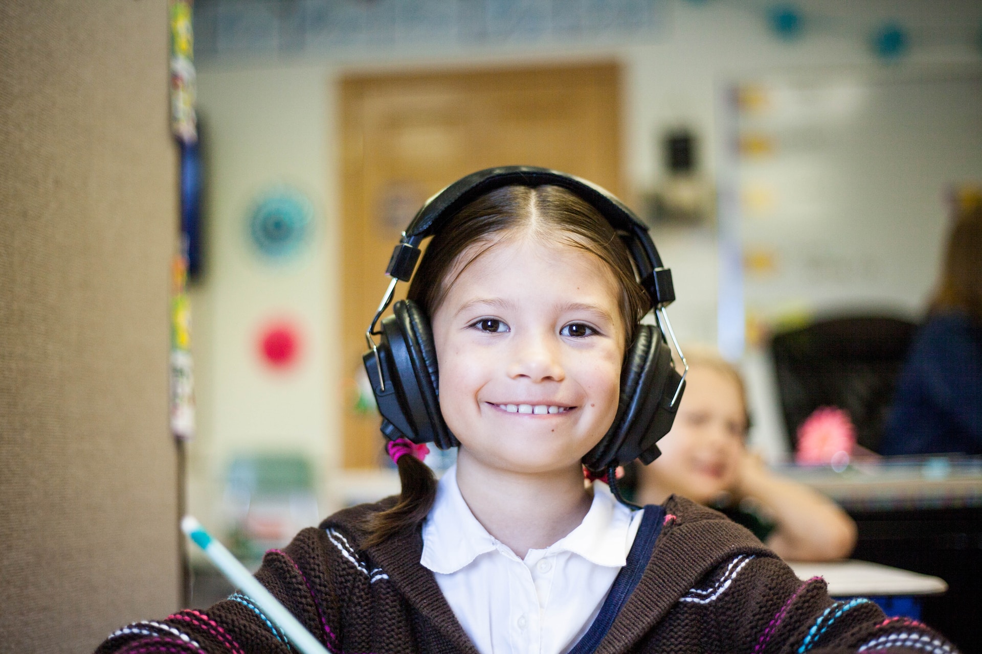 Young girl wearing headphones in class.