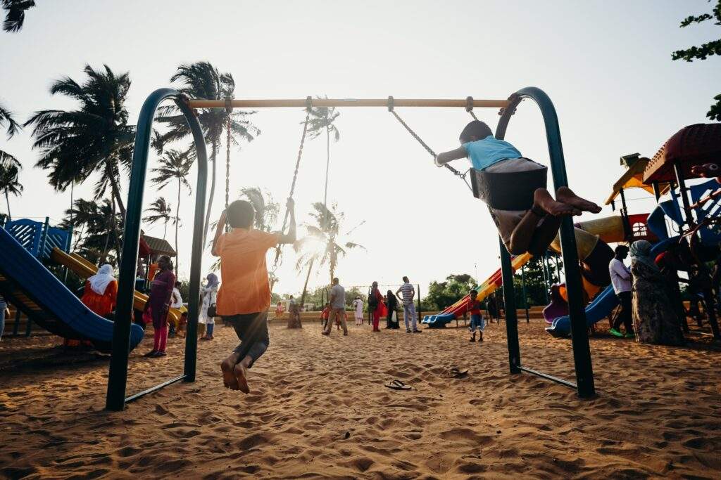 Kids are swinging on the swing set at a playground--Playground