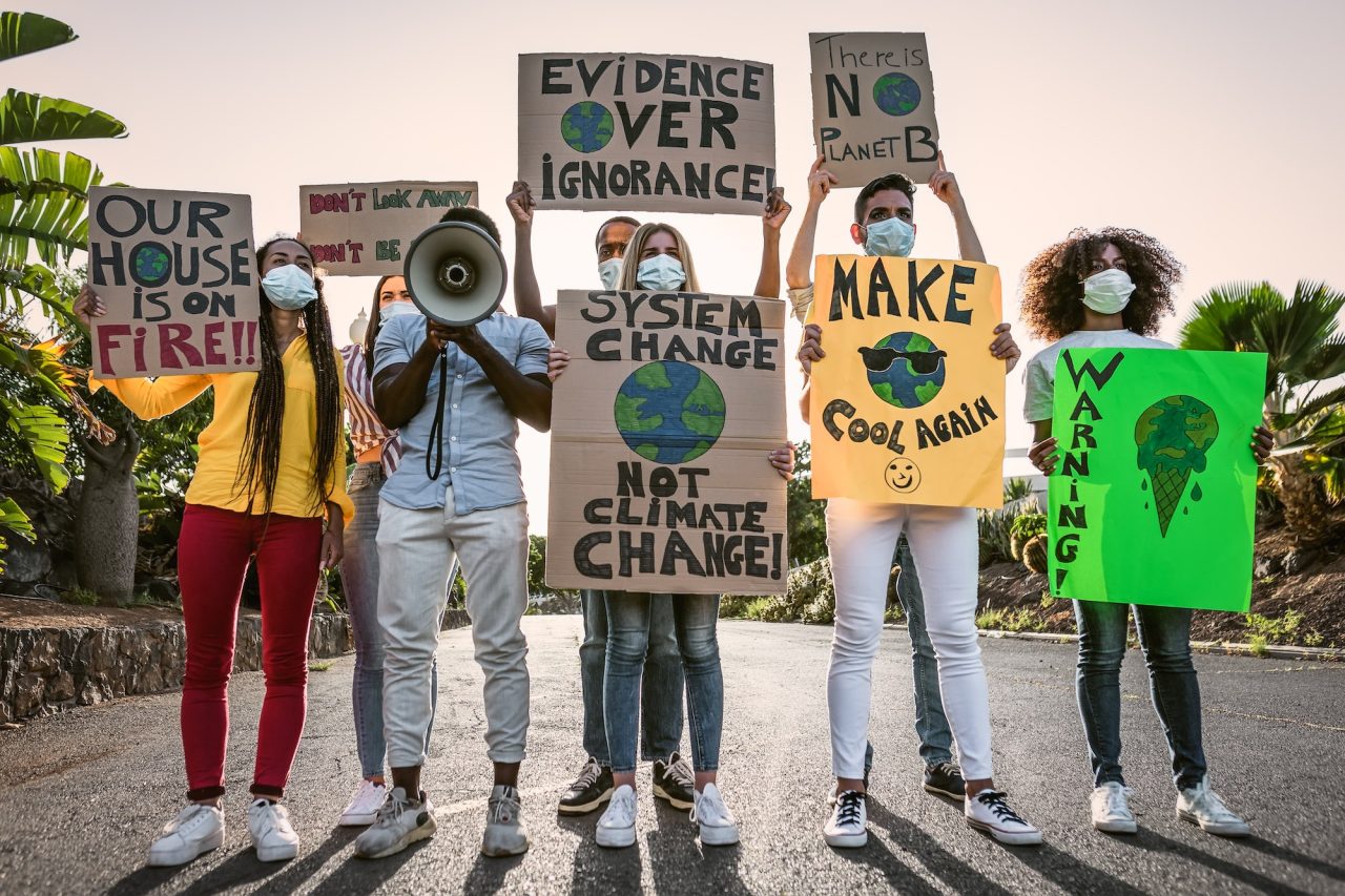 A group of young activists hold signs encouraging climate action