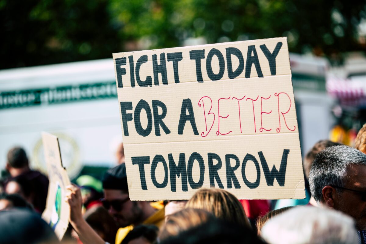 A picture of a protest, zoomed in on a sign that says "Fight for a better tomorrow"