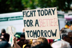 A picture of a protest, zoomed in on a sign that says "Fight for a better tomorrow"