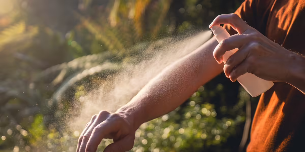 Child spraying bug repellent on their arm--