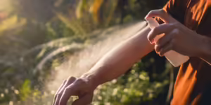 Child spraying bug repellent on their arm--