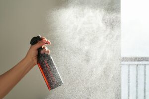 A woman's hand sprays an air freshener in a room--fragrances in child care