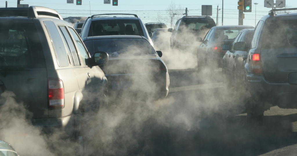Cars sitting and idling at a stoplight