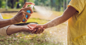 Dad and Son Use Mosquito Spray.Spraying Insect Repellent on Skin Outdoor