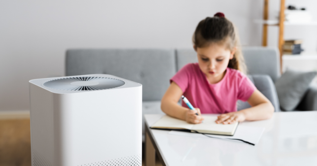 Child colors in the background as a portable air cleaner site in the foreground
