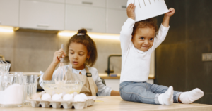 Two small children mix eggs into batter in a kitchen--- PFAS in Child Care