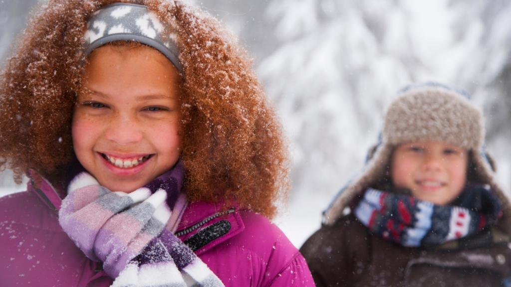 Two smiling children outside in snowy weather - Alaska children's environmental health