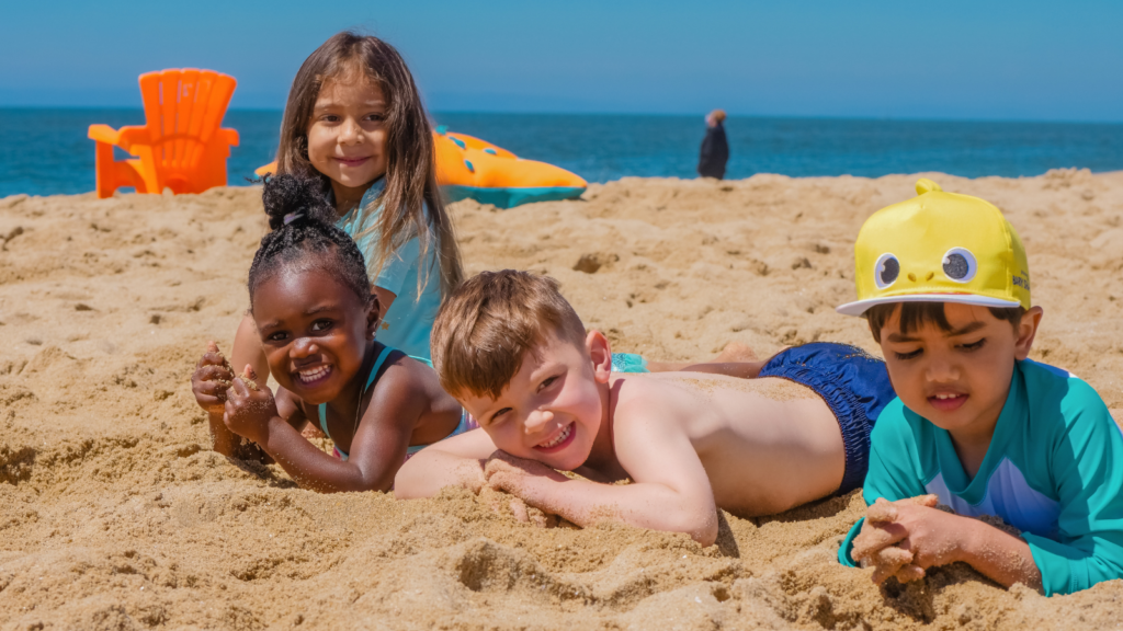 Four children lying on the sand at a beach -- Florida children's environmental health