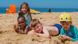 Four children lying on the sand at a beach -- Florida children's environmental health