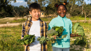 Two children standing up holding produce - Indiana children's environmental health