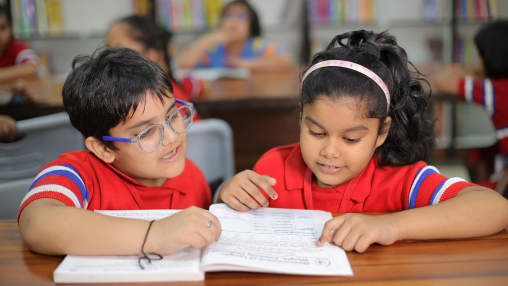 Two children at school reading a workbook together - Montana children's environmental health