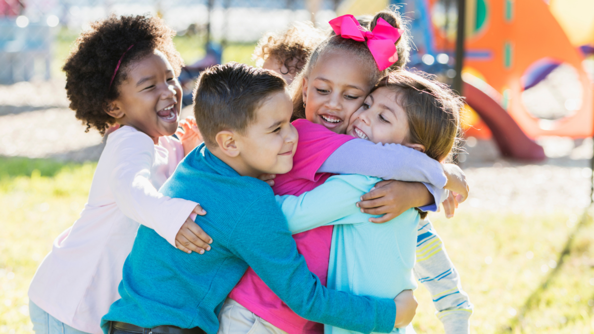 Children on a playground in a group hug - Nevada children's environmental health
