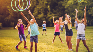Children outside throwing hula hoops in the air - New Hampshire children's environmental health