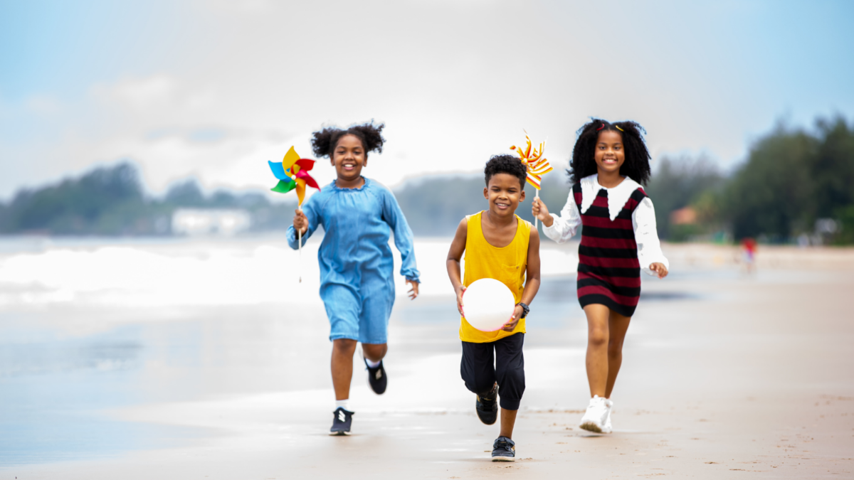 Children running on a beach with toys in their hands - New Jersey children's environmental health
