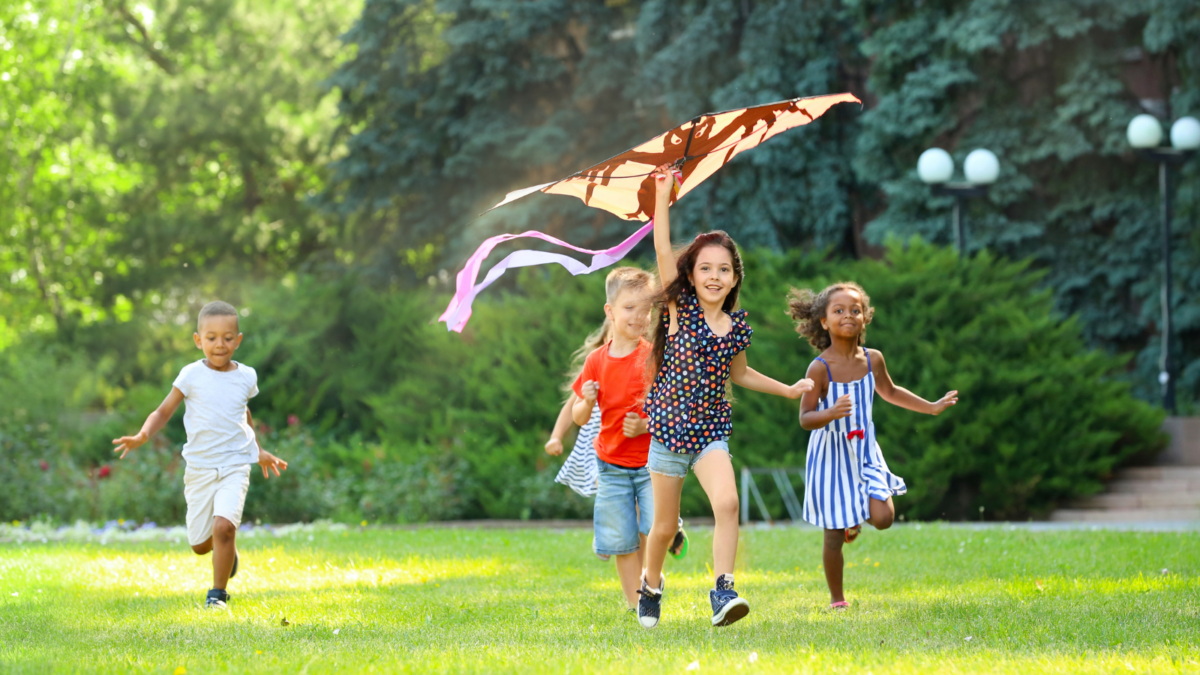A group of children running outside with a kite -- Ohio children's environmental health