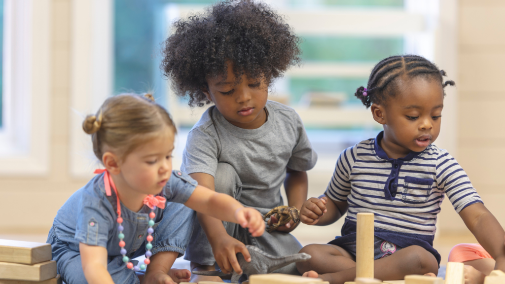 Three children playing with wooden blocks -- South Dakota children's environmental health
