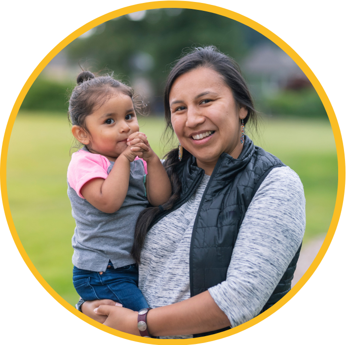 A young Native American mother holds her toddler daughter
