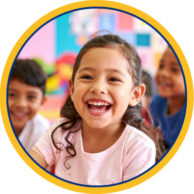 A young latina girl in a classroom laughing
